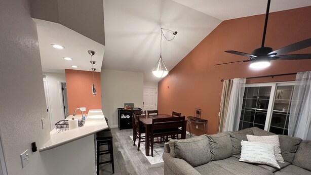 A modern living room with a sofa, a dining table, and a kitchen area with a counter. - Edwards condo with attached garage (Edwards)