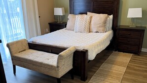 A bedroom with a large bed, a chair, two nightstands, and a floor lamp. - Edwards condo with attached garage (Edwards)