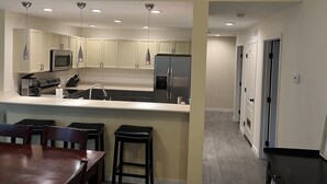 A modern kitchen with white cabinets, stainless steel appliances, and pendant lighting. - Edwards condo with attached garage (Edwards)