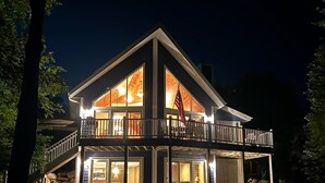 Une maison à deux étages dotée d’un balcon, de grandes fenêtres et d’un drapeau.