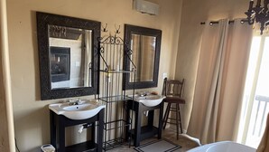 A bathroom with two sinks, a bathtub, and a chair.