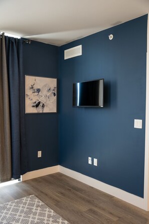 Relax in a stylish space with a mounted TV, artwork, and comfortable seating area.