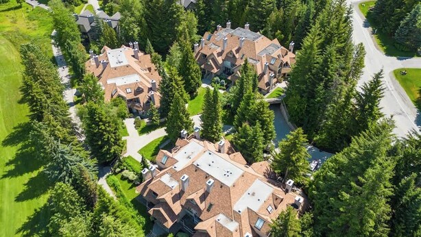 A residential area with multiple houses surrounded by dense trees.