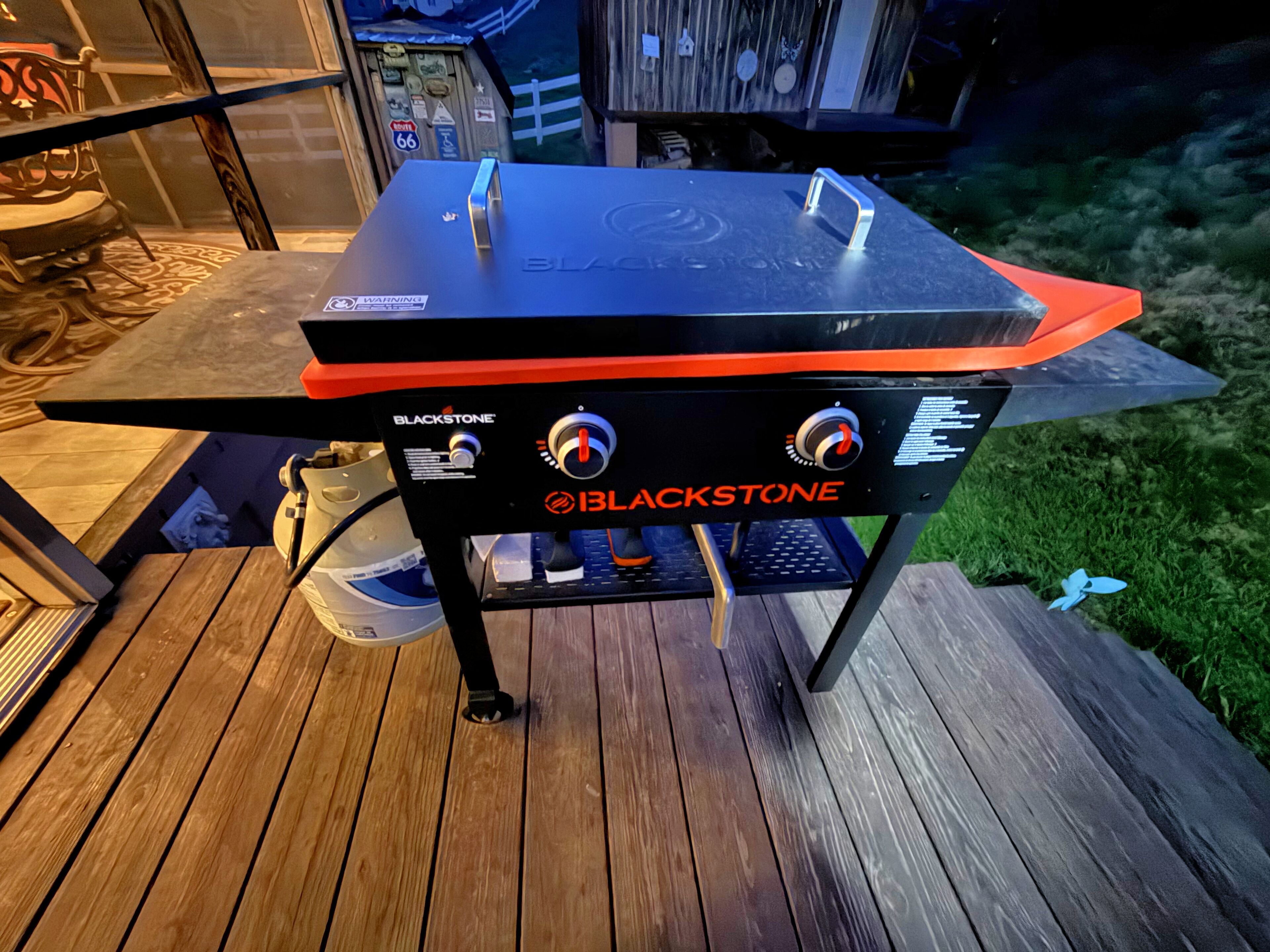 A Blackstone grill on an outdoor wooden deck.