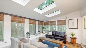 A spacious living room with a large window, a sofa, a coffee table, and a fireplace. - Lakeview|! HotTub| Game Room| Community Pool! (Pocono Summit)