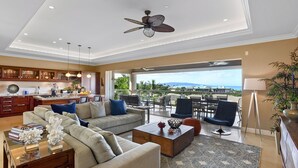 Ein großzügiges Wohnzimmer mit Sofa, Couchtisch und Blick ins Freie.