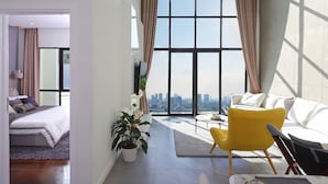 A modern living room with a large window, a bed, a yellow armchair, and a white sofa. - THE PENINSULA PHNOM PENH (Phnom Penh)