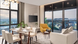 A modern living room with a dining area, large windows, and a city view. - THE PENINSULA PHNOM PENH (Phnom Penh)