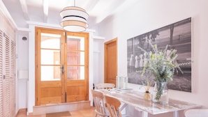 A dining area with a wooden table, chairs, and a large painting on the wall.