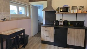 Une cuisine compacte avec des meubles en bois, un four à micro-ondes encastré et une cuisinière à gaz.