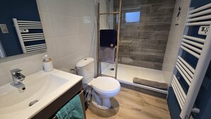 Une salle de bain moderne équipée d’une douche, de toilettes et d’un lavabo.