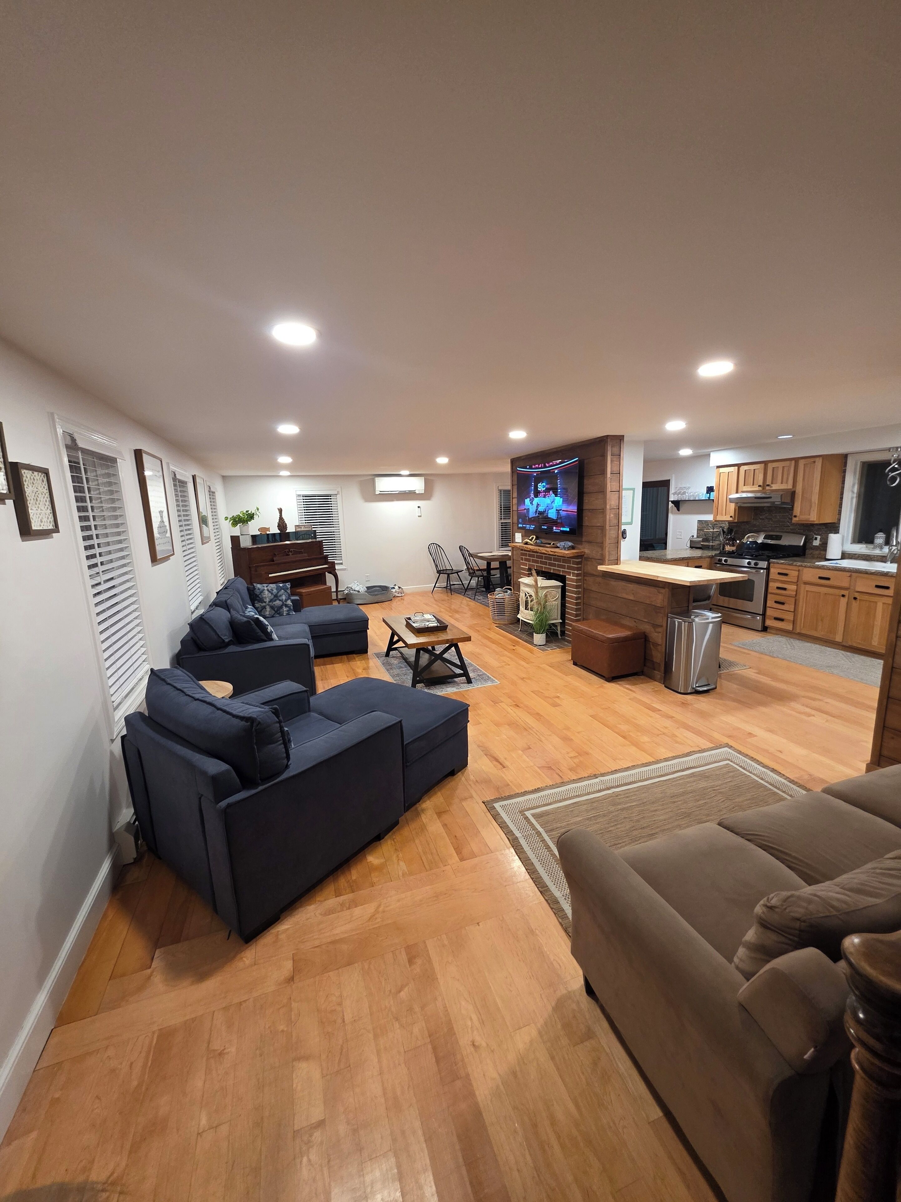 Ein modernes Wohnzimmer mit Ecksofa, Couchtisch und Fernseher.