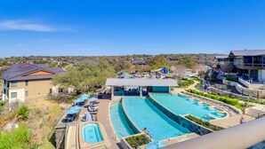 Een resort met meerdere zwembaden, buitenzitgedeeltes en uitzicht op het omliggende landschap.