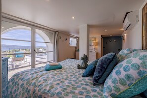 A bedroom with a large bed, a view of the outdoors, a desk, and a chair. - Luxury and Modern villa with magnificent sea view & Gulf of Saint Tropez (Cavalaire-sur-Mer)
