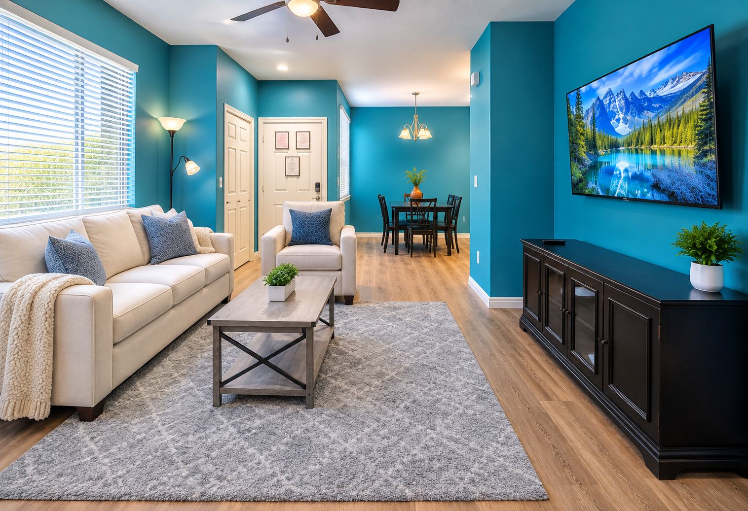A living room with a sofa, coffee table, and a TV mounted on the wall.