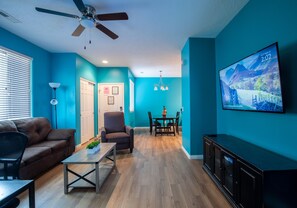 Relax in this stylish living room with a sofa, armchair, and dining table.