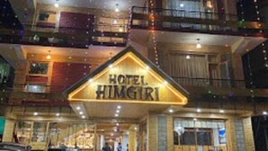 Ein mehrstöckiges Hotel mit Balkonen und einem Schild mit der Aufschrift 'HOTEL HIMGIRI'.