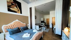 Un dormitorio con una cama grande, un escritorio, una silla, un televisor y una araña.