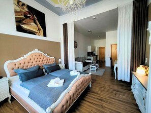 A bedroom with a large bed, a desk, a chair, a television, and a chandelier. - Apartment Paris up to 3 people (Mühlhausen/Thüringen)
