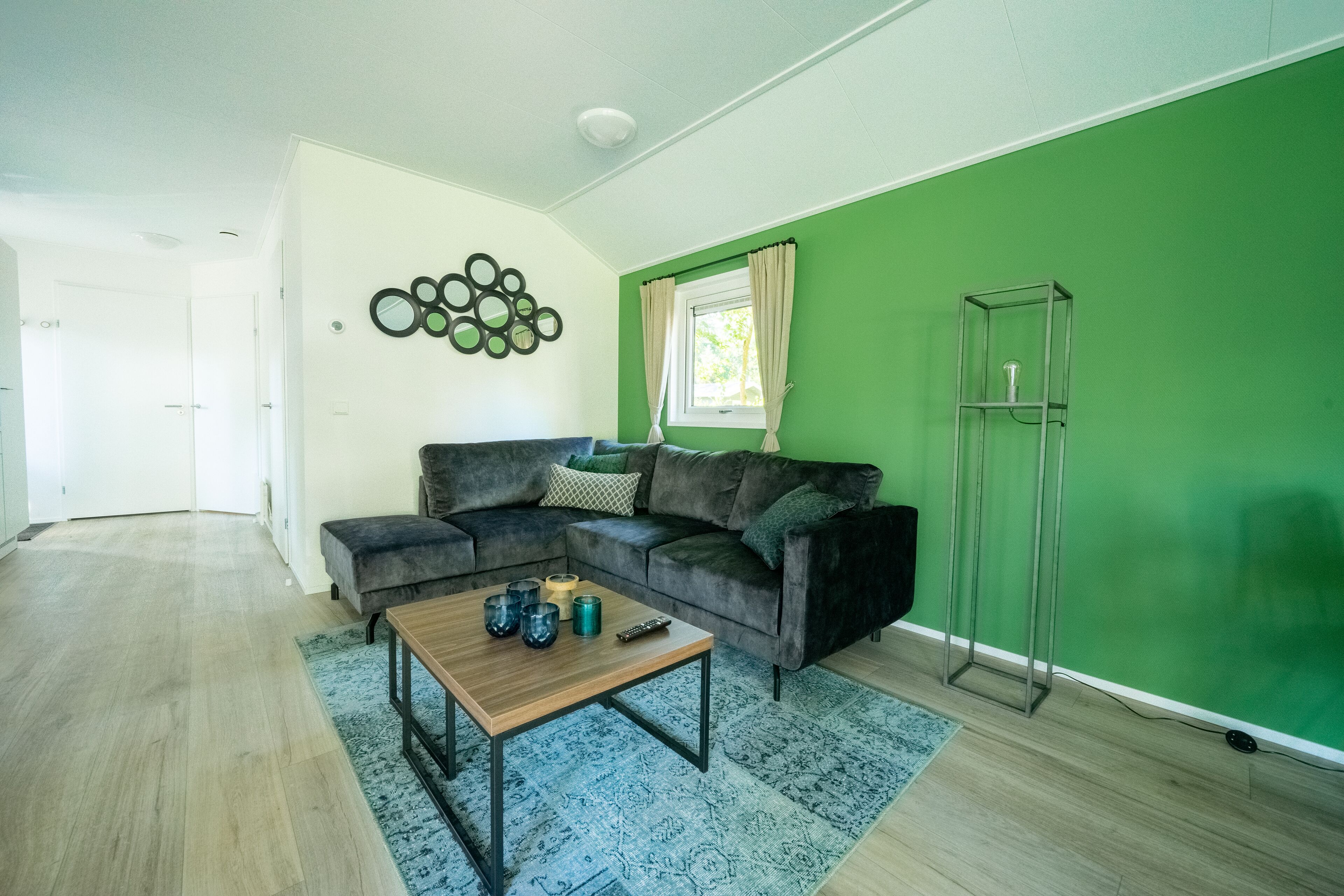 Una sala de estar con un sofá modular, una mesa de centro y un aparador de vidrio.