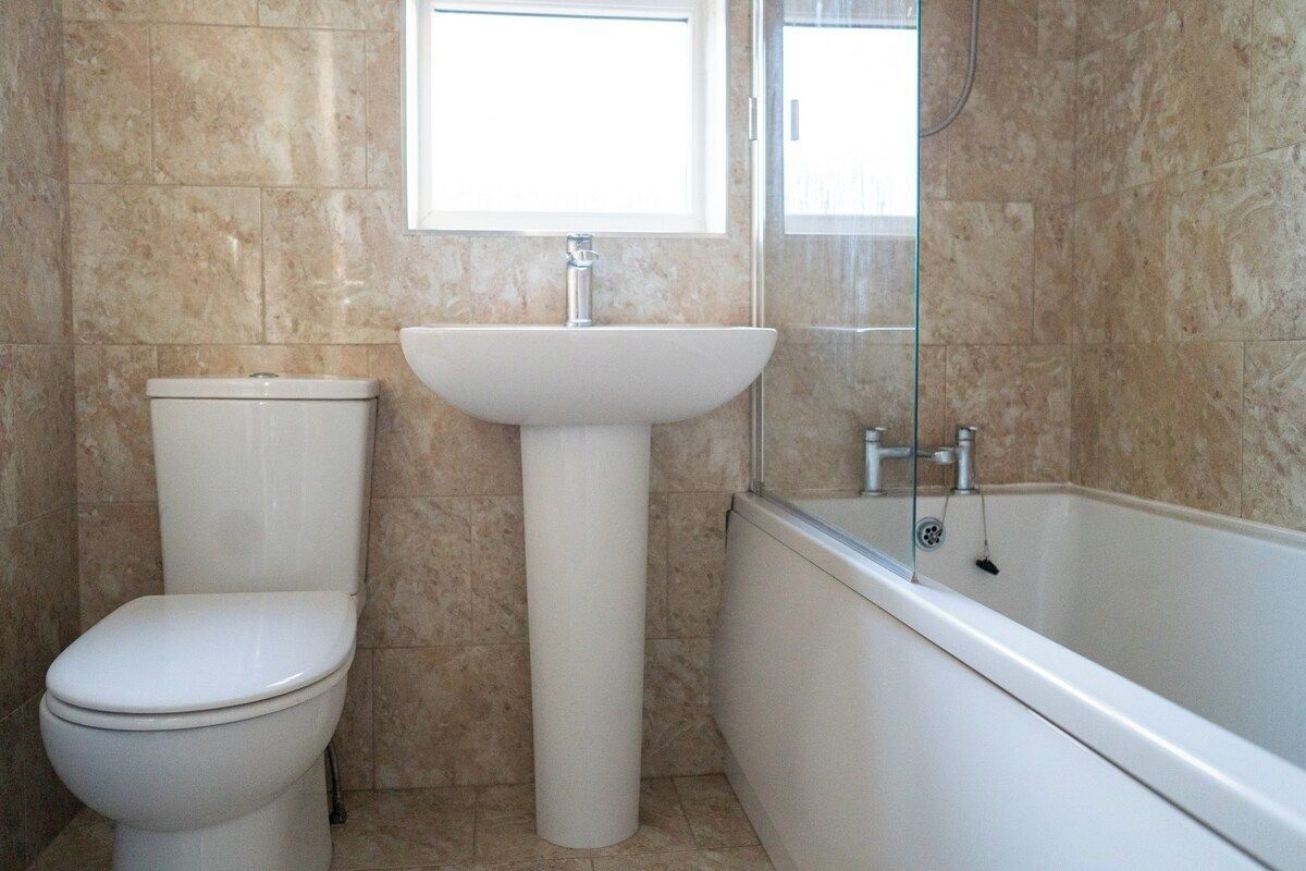 A bathroom with a toilet, sink, and bathtub.