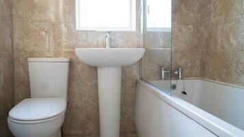 A bathroom with a toilet, sink, and bathtub.