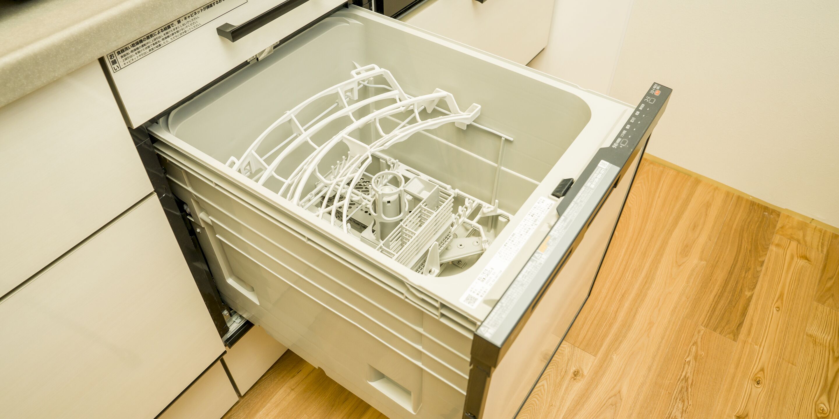 An open dishwasher with racks and utensils inside.