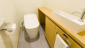 Een moderne badkamer met toilet, wastafel en handdoekhouder.