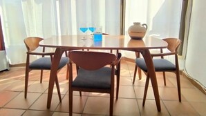 Un coin repas avec une table ronde, quatre chaises et un vase.