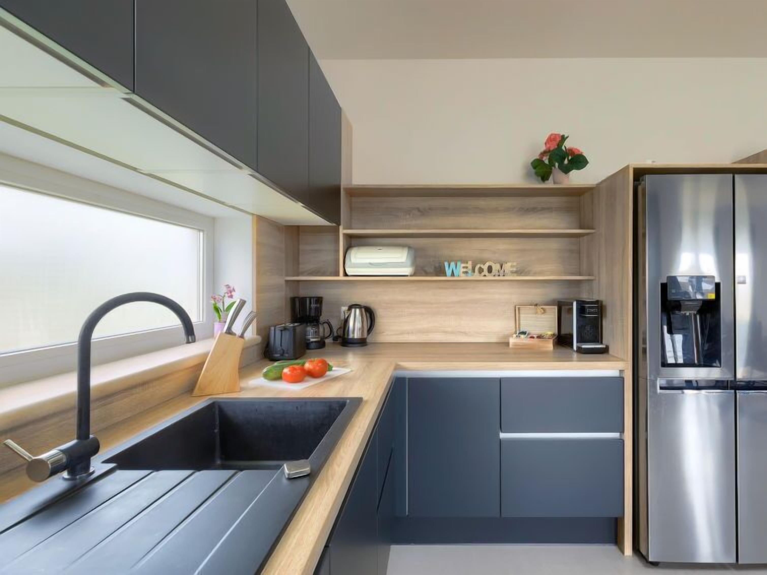 Una cucina moderna con lavello integrato, macchina da caffè, tostapane e dispenser per l'acqua.