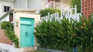 A building with a turquoise door, a sign reading "malanhari", and lush greenery. - Malam Hari ApartHotel (Canggu)