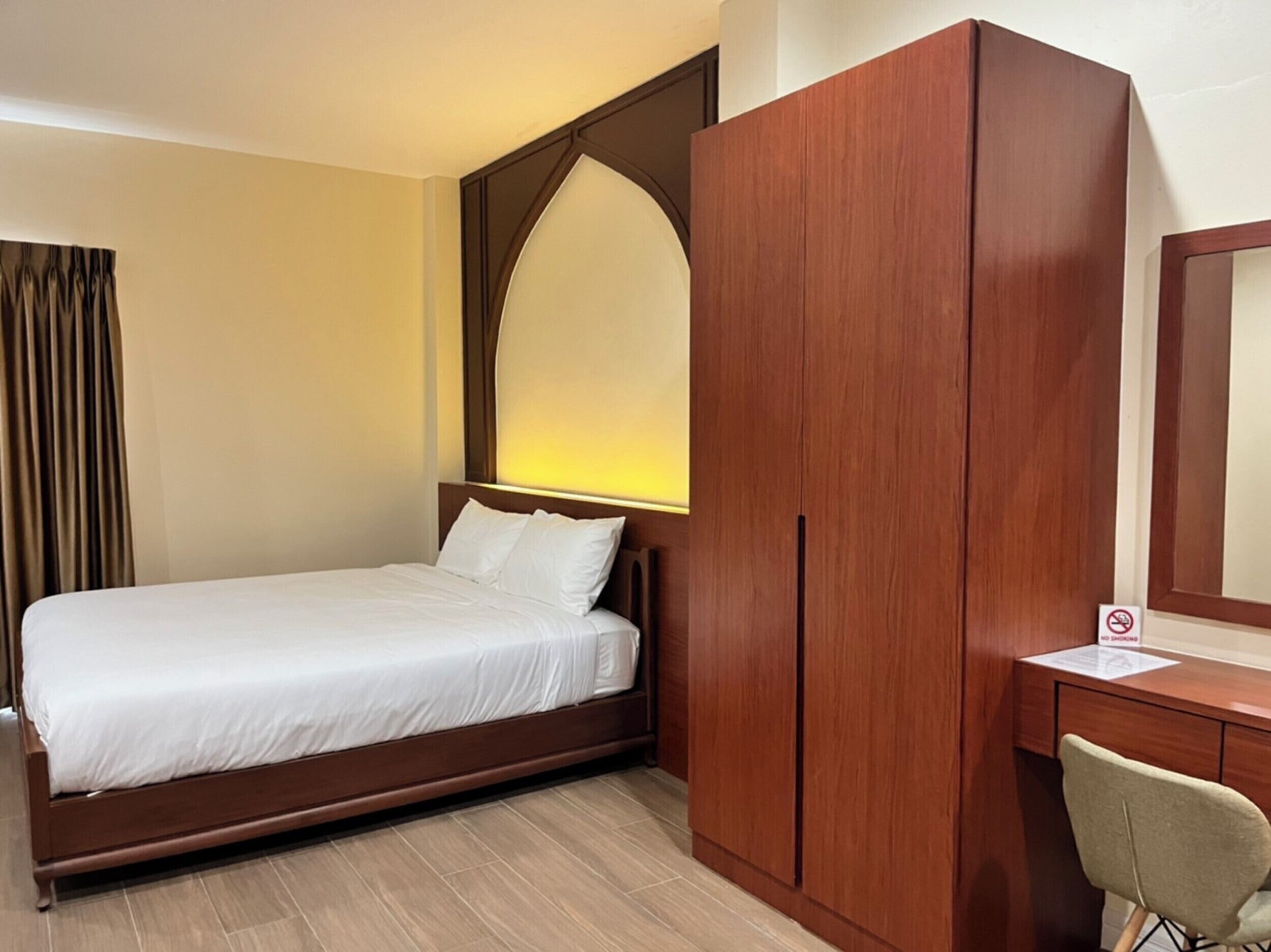 Una habitación de hotel con cama, escritorio y armario.