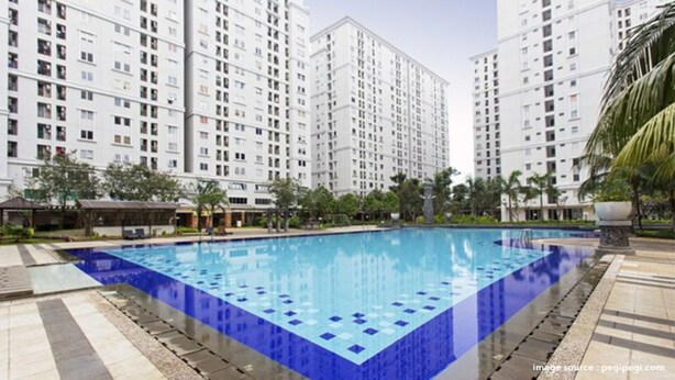 Une piscine entourée d’immeubles d’habitation de grande hauteur.