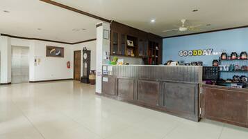 A reception area with a counter, a clock, and a wall with 'GOODDAY' signage.
