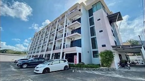 A multi-story building with balconies, a parking area with cars, and a clear sky. - Goodday Kathu (Kathu)
