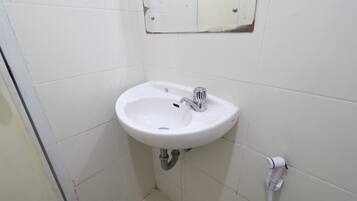 A small, white bathroom with a sink and mirror.