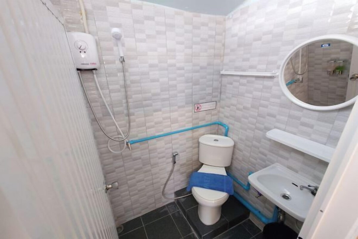 Un baño pequeño con inodoro, lavamanos y ducha.