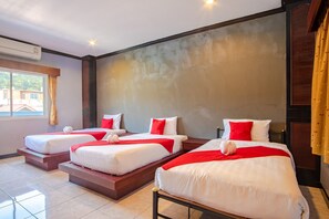 Ett hotellrum med tre sängar, ett stort fönster och en luftkonditioneringsanläggning.