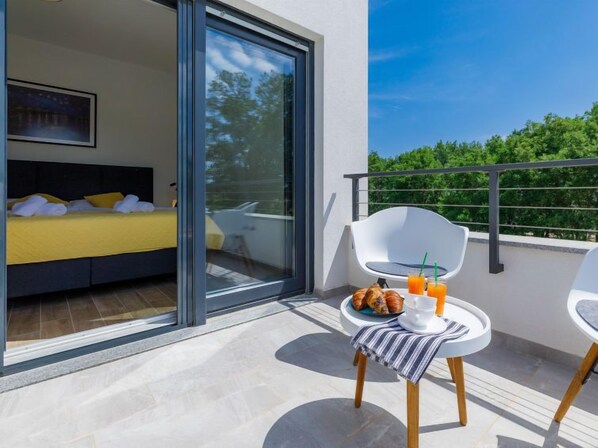 Varanda com cama, mesa de café da manhã e itens para o café da manhã.