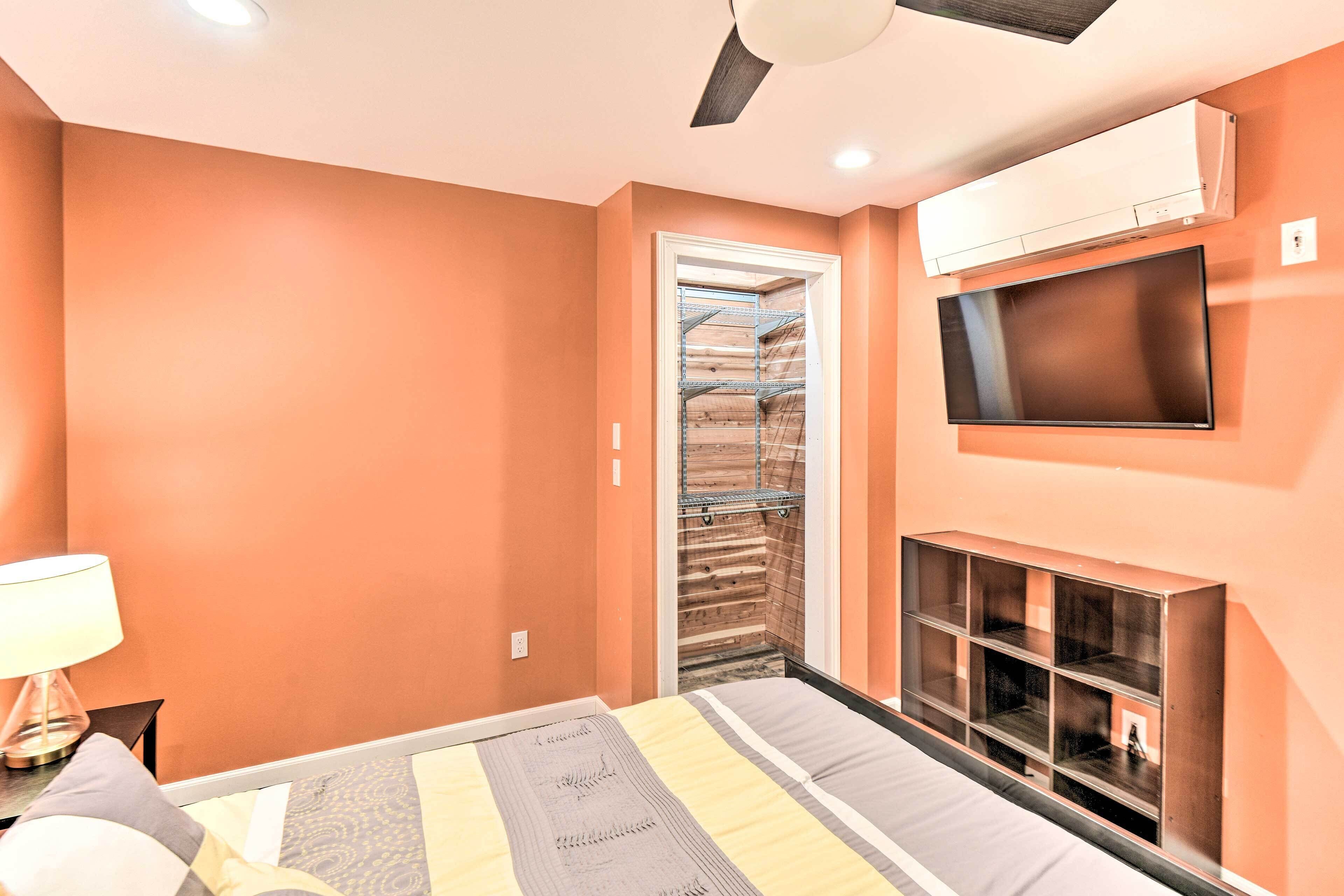 Une chambre à coucher comprenant un lit, un téléviseur, un ventilateur de plafond et un appareil de climatisation.