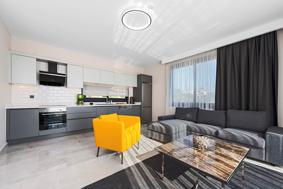 A modern living room with a sofa, a coffee table, and a bright yellow chair.