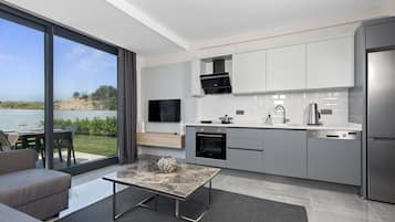 Una cocina moderna con un amplio ventanal, un rincón de comedor con sofá y vistas al exterior.