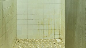 A small, tiled shower room with a single showerhead and a door. - Spot ON 90536 Bens Maju Foreststay (Malacca City)
