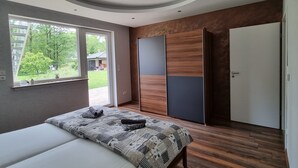 Une chambre à coucher moderne avec un lit, une armoire et une porte.