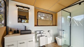 Ein modernes Badezimmer mit Waschtisch, Handtuchhalter, Toilette und einer Duschkabine aus Glas.