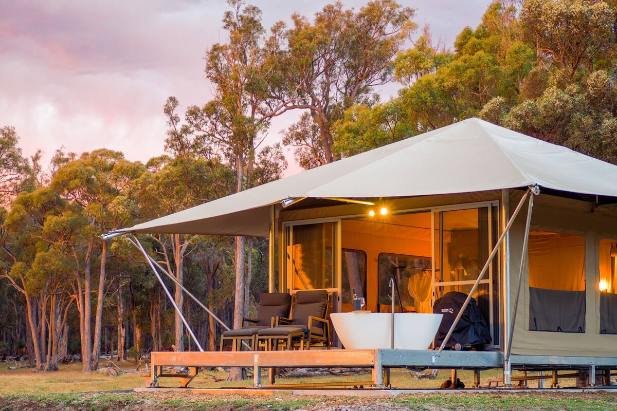 A tent with a covered patio area, including chairs and a table.