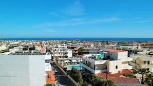 A coastal town with a mix of residential buildings and a prominent hotel with a swimming pool. - Selena View Hotel & Apartments (Hersonissos)
