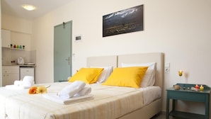 A hotel room with a bed, a nightstand, a painting, and a bathroom visible in the background. - Selena View Hotel & Apartments (Hersonissos)