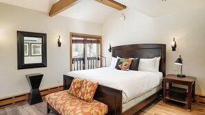 A bedroom with a large bed, a bench, a bedside table, a window, and a framed picture on the wall. - Old Hundred Unit 104 | Sunny, Corner Townhouse, Treetop Views, 3 Blocks to Aspen Mtn (Aspen)