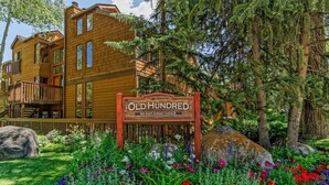A wooden multi-story building with a sign reading "Old Hundred 900 East Durant Avenue." - Old Hundred Unit 104 | Sunny, Corner Townhouse, Treetop Views, 3 Blocks to Aspen Mtn (Aspen)